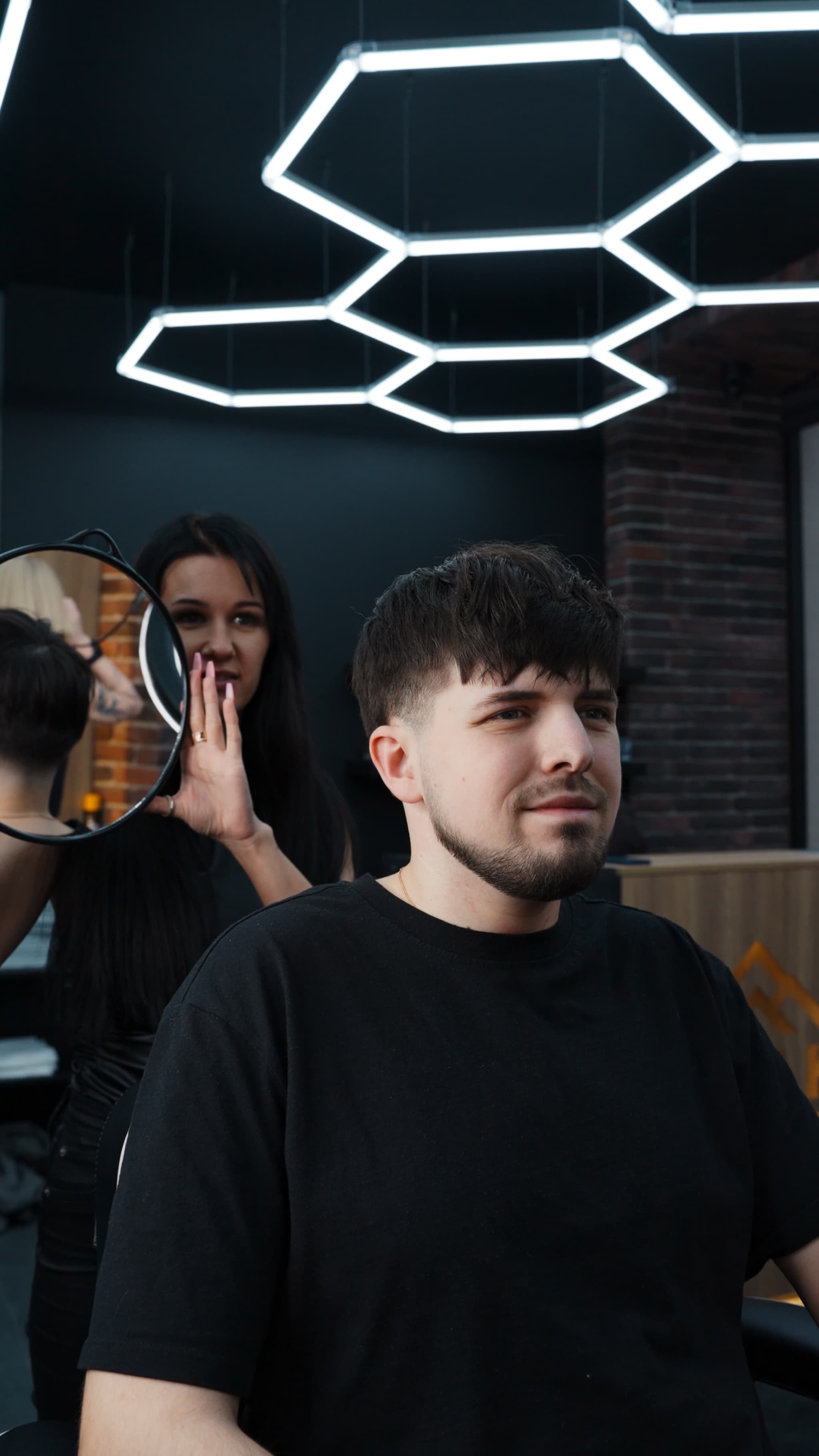 Vīrietis ar ieveidotu bārdu un matu griezumu Rīgas frizētavā