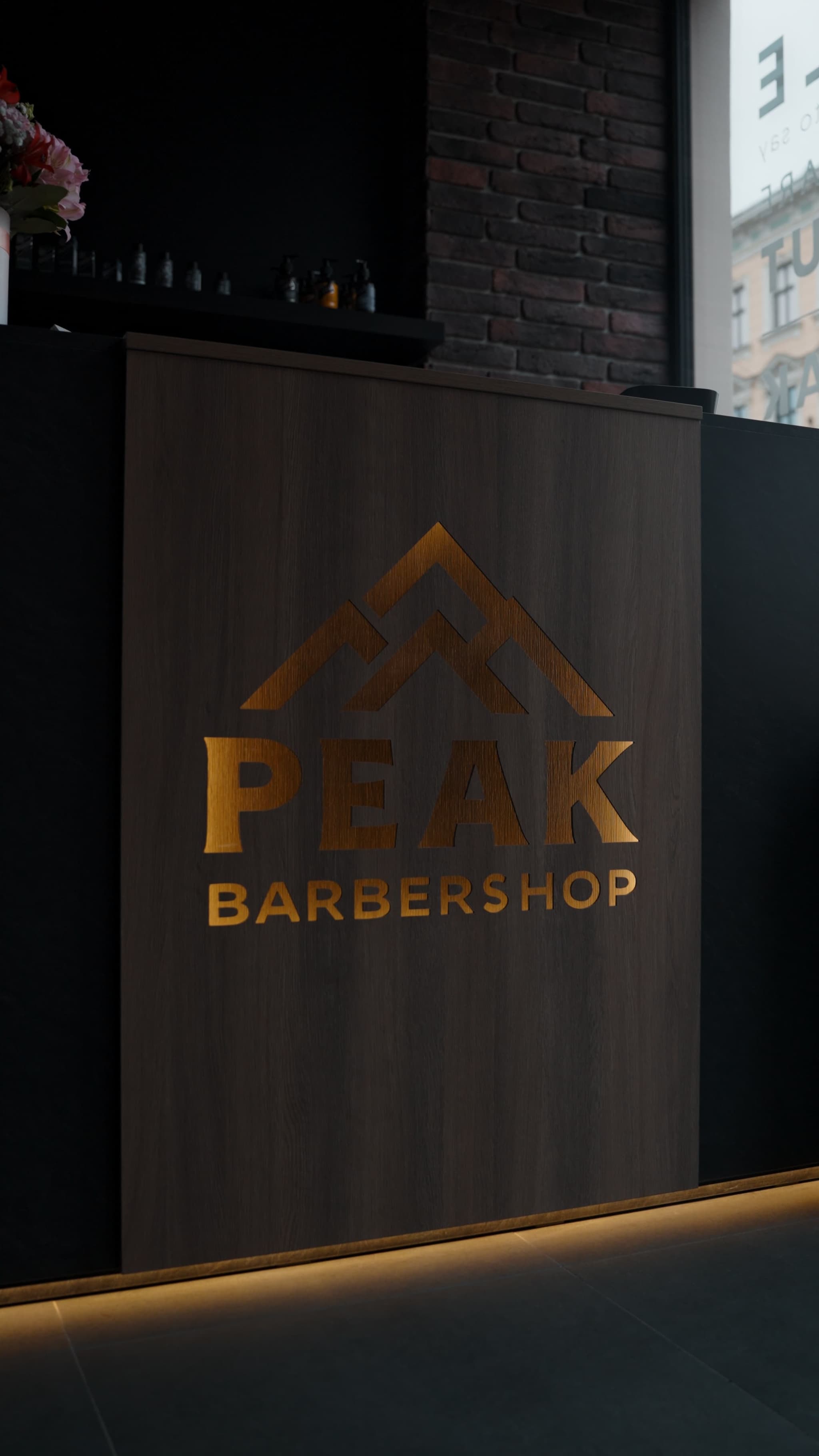 Peak Barbershop recepcijas lete ar zelta logo Rīgā